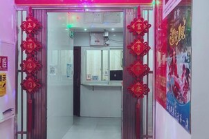 Uma área de recepção com balcão, detalhes em vermelho e um cartaz na parede.