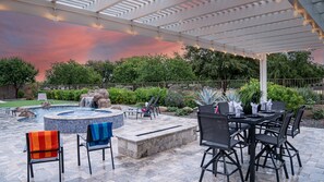 An outdoor patio with a hot tub, seating, and a pergola with string lights. - Desert Queen Queen Creek (Queen Creek)