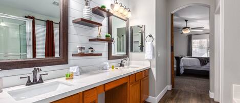 Une salle de bain moderne avec un grand miroir, des meubles en bois et un plan de travail blanc.