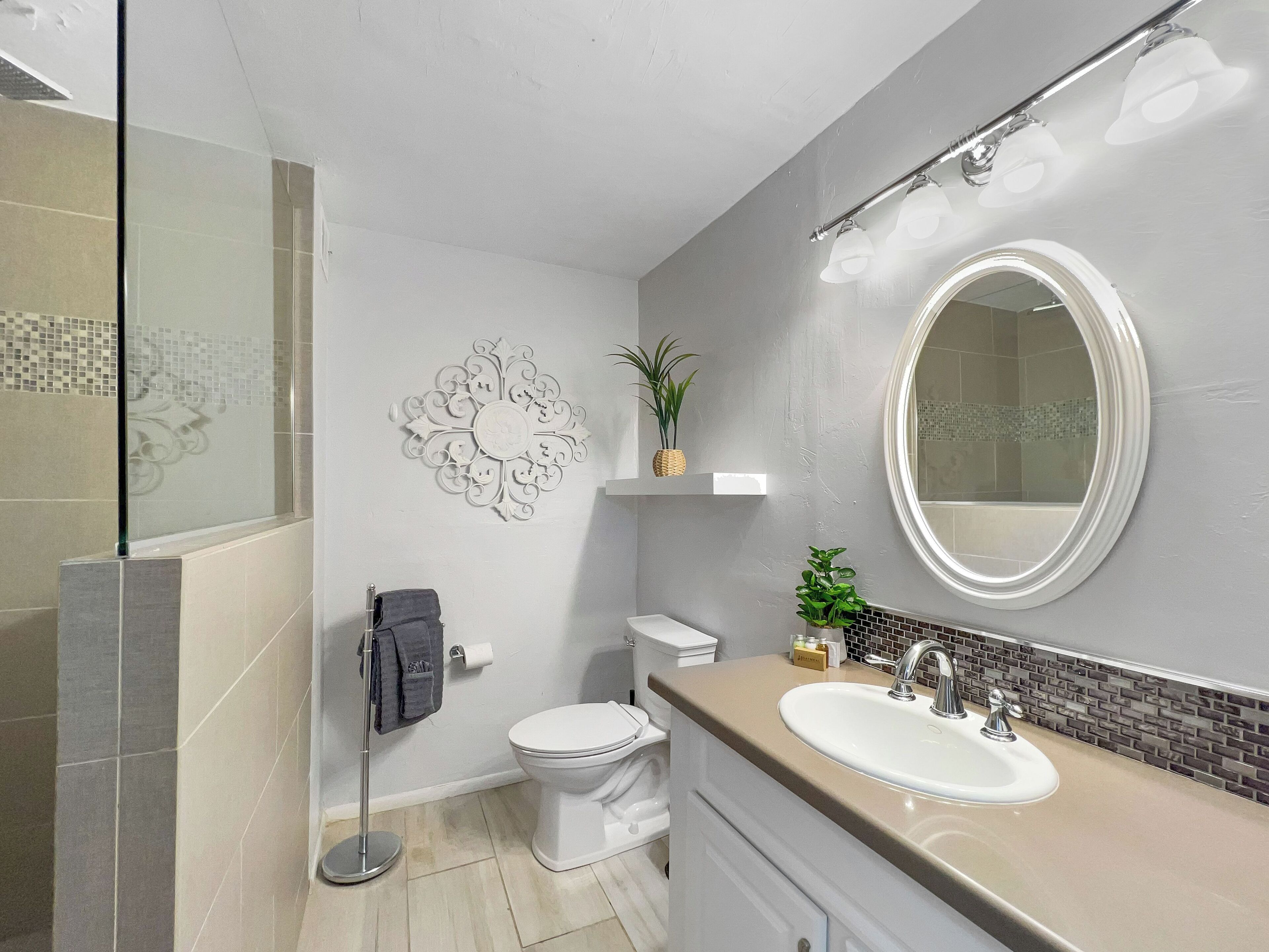 A modern bathroom with a toilet, sink, and shower.