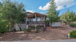 A modern two-story house with a covered porch, surrounded by trees and a landscaped yard. - Lookout Payson (Payson)