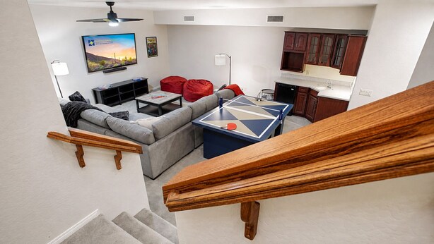 A living room with a sofa, coffee table, and ping pong table. - Lynx Chandler/ocotillo (Chandler)