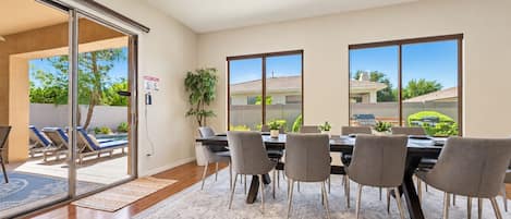 A dining area with a table, chairs, and a ceiling fan.