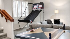 A living room with a basketball hoop, a couch, a coffee table, and a lamp. - Lynx Chandler/ocotillo (Chandler)