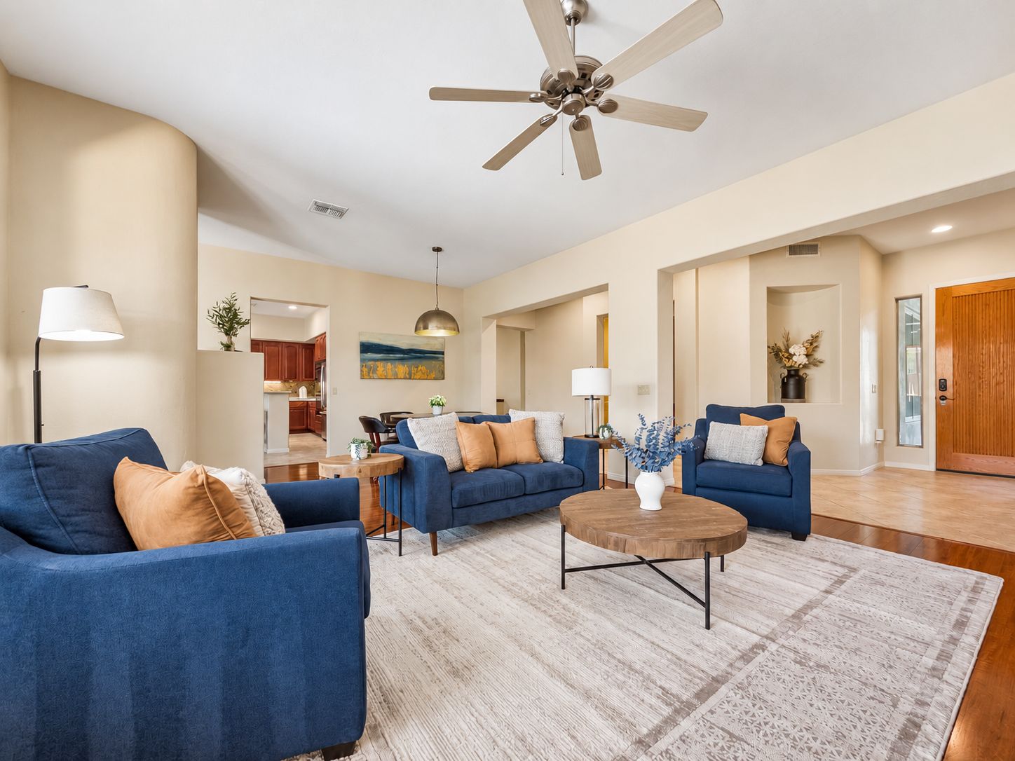 A spacious living room with two sofas, a coffee table, and a ceiling fan.