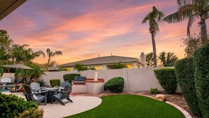 A backyard with a barbecue area, outdoor seating, and a well-maintained lawn. - Lynx Chandler/ocotillo (Chandler)