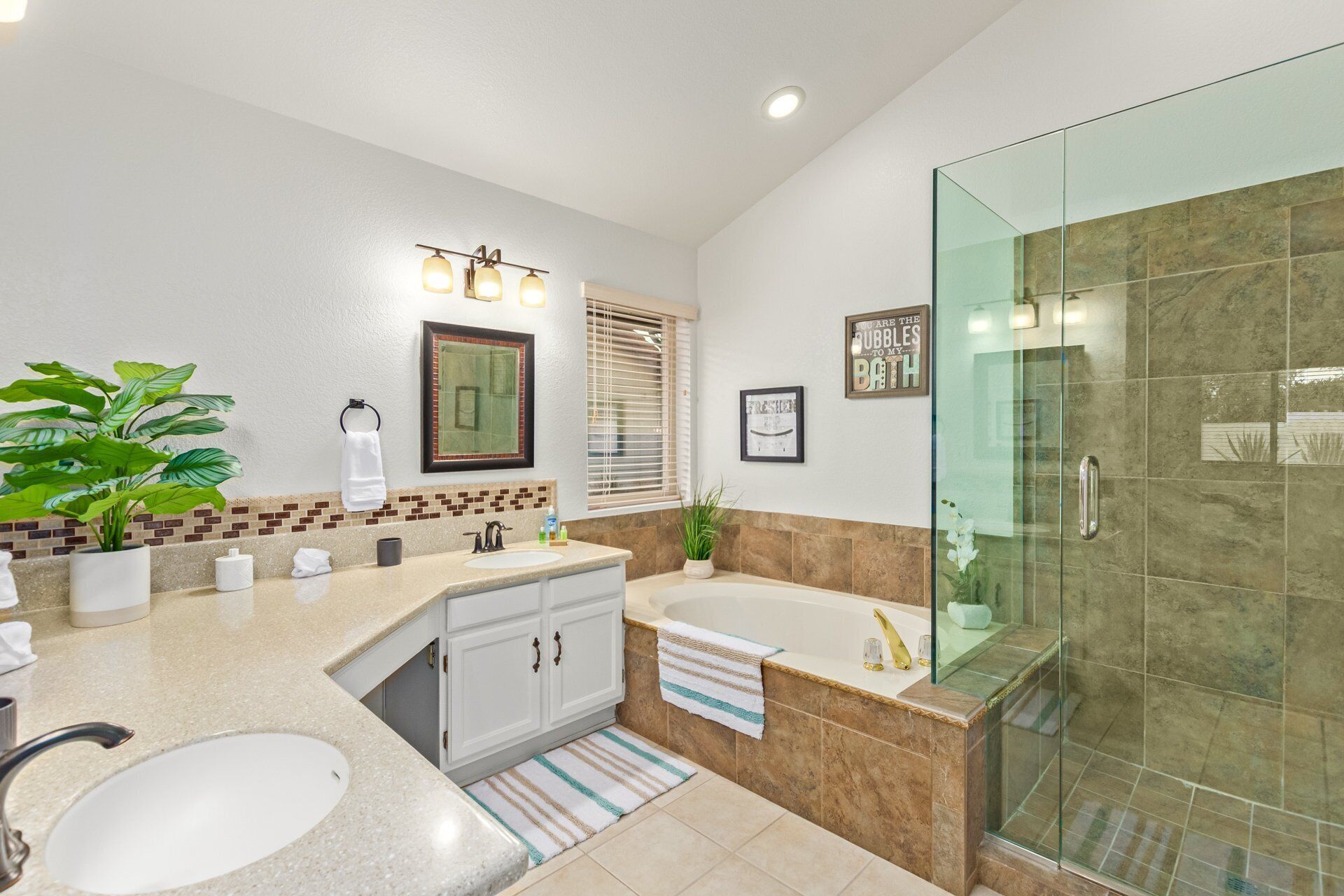 Un baño moderno con bañera, ducha con mampara de vidrio y lavabo.