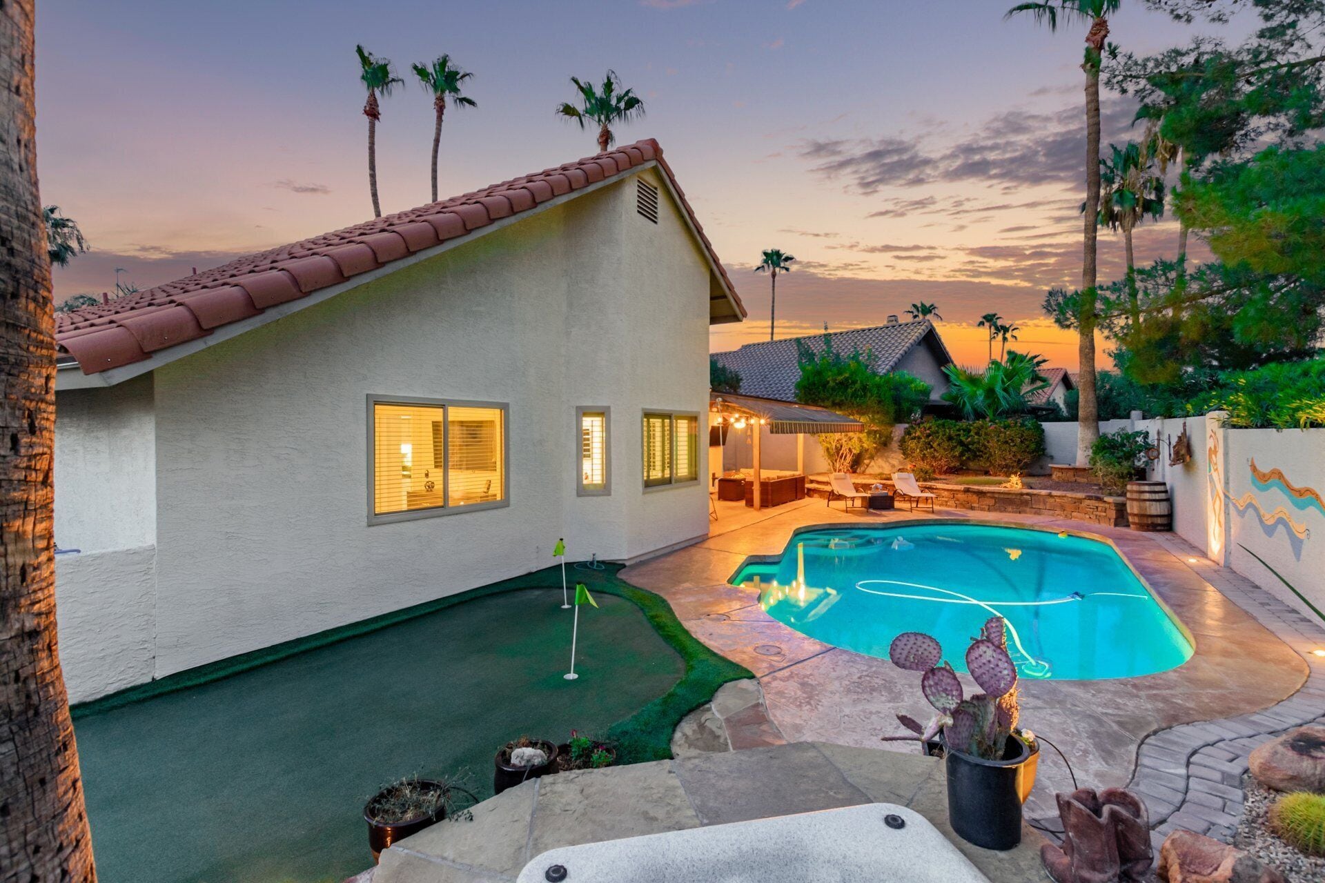 Una casa con piscina, patio y un pequeño jardín.