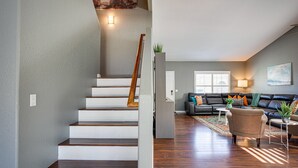 A staircase leading to a living area with a sofa, coffee table, and a plant. - Ocotillo Glendale (Glendale)