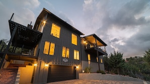 A modern two-story house with a dark exterior, a covered front porch, and a garage. - Ruin Hill Kokopeli Pine (Pine)