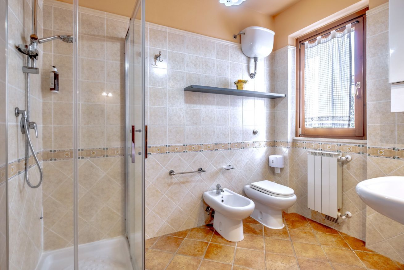 Une salle de bain équipée d’une douche, d’un bidet, de toilettes et d’un radiateur.
