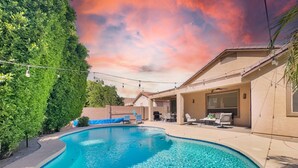 Une piscine à l’eau claire, entourée d’une terrasse aménagée avec des meubles d’extérieur et un espace salon abrité.