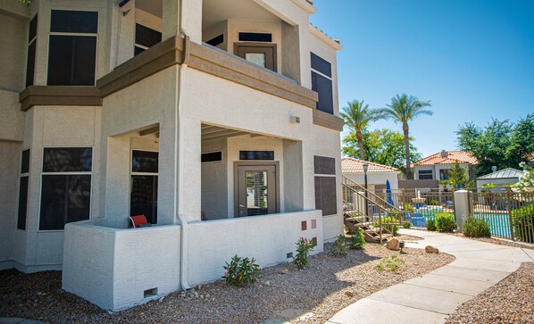 A modern two-story house with a covered patio, a swimming pool, and a landscaped garden.