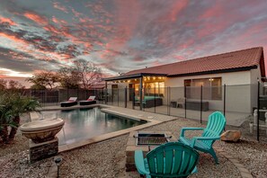 A backyard with a swimming pool, outdoor seating, and a house with a red-tiled roof. - Stratford Place Queen Creek (San Tan Valley)