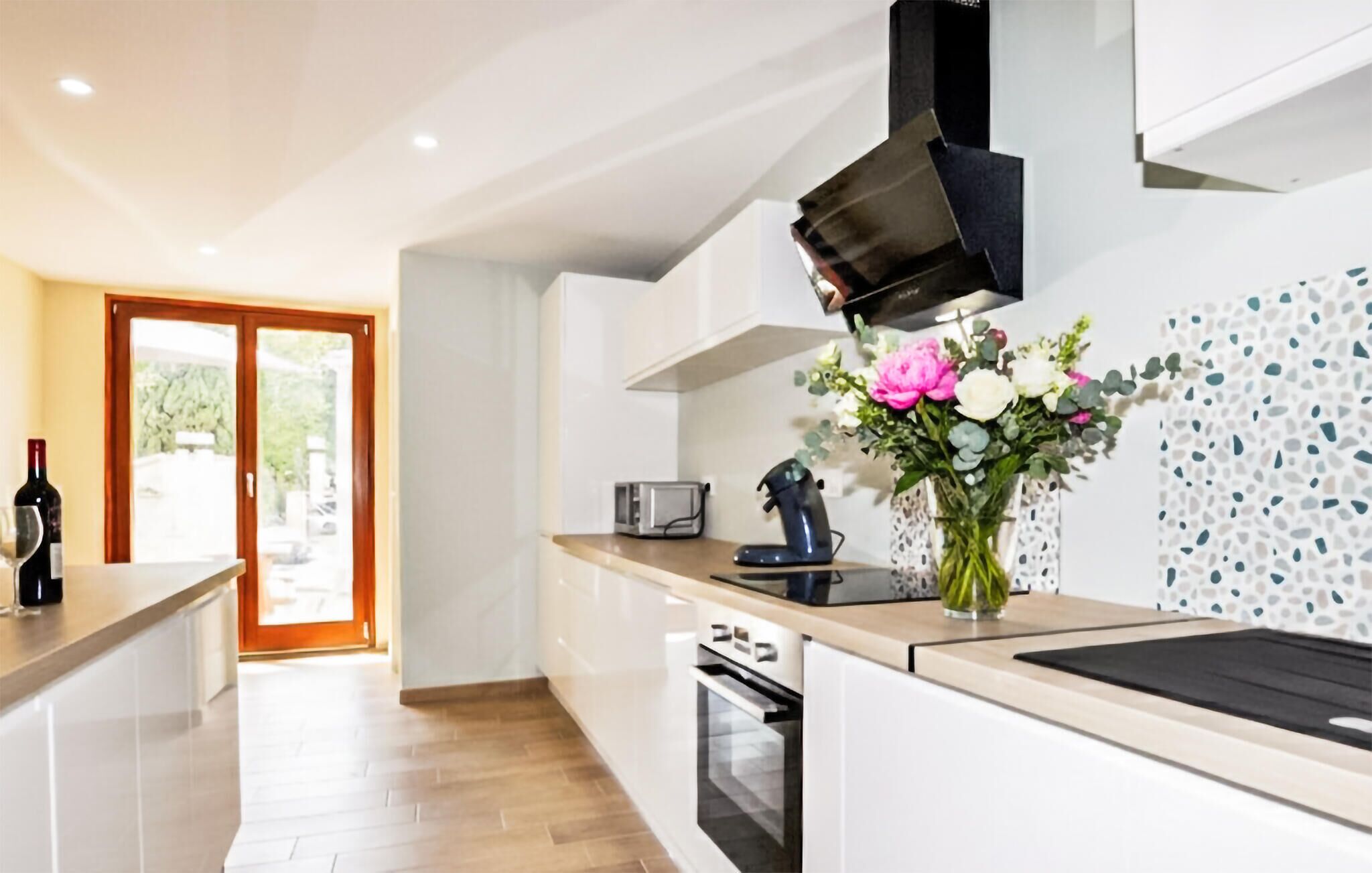 A modern kitchen with a built-in oven, a toaster, and a coffee machine.