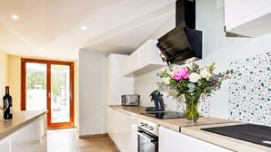 A modern kitchen with a built-in oven, a toaster, and a coffee machine.
