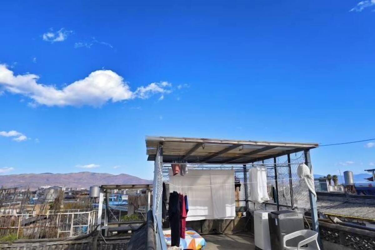 Une terrasse sur le toit dotée d’une structure métallique, d’un lit et d’un petit espace clos avec un toit.