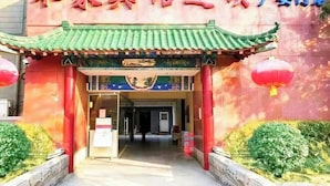 Un bâtiment traditionnel chinois, avec une porte d’entrée rouge et un toit vert.
