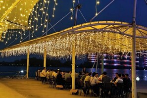 An outdoor dining area with a covered structure and string lights. - Wei Select Xueye Hotel (Jinan)