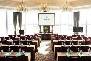 A conference room with rows of tables and chairs, a projector screen, and a television. - Wei Select Xueye Hotel (Jinan)