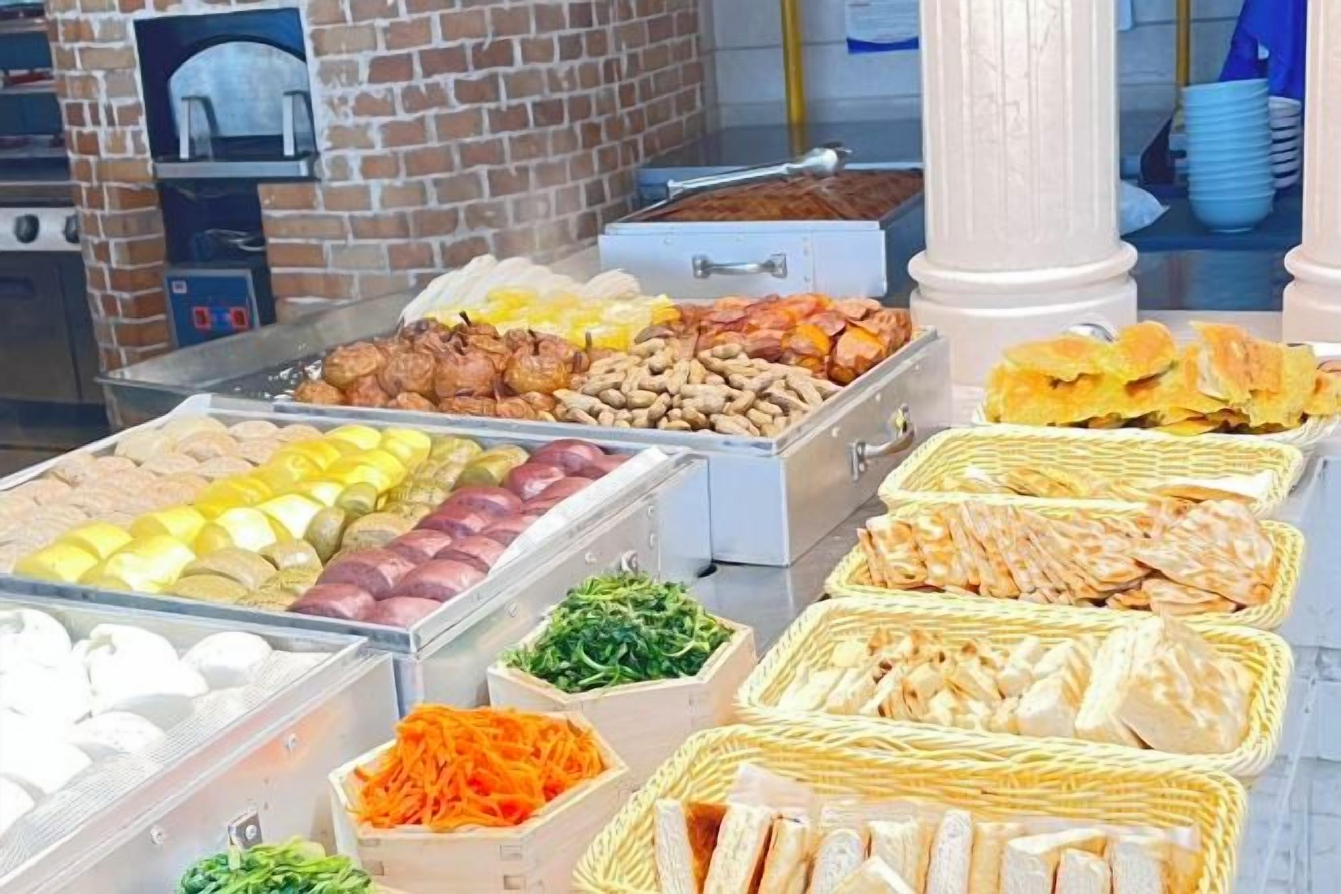 Een buffet met diverse soorten eten, waaronder vlees, kaas en groenten.