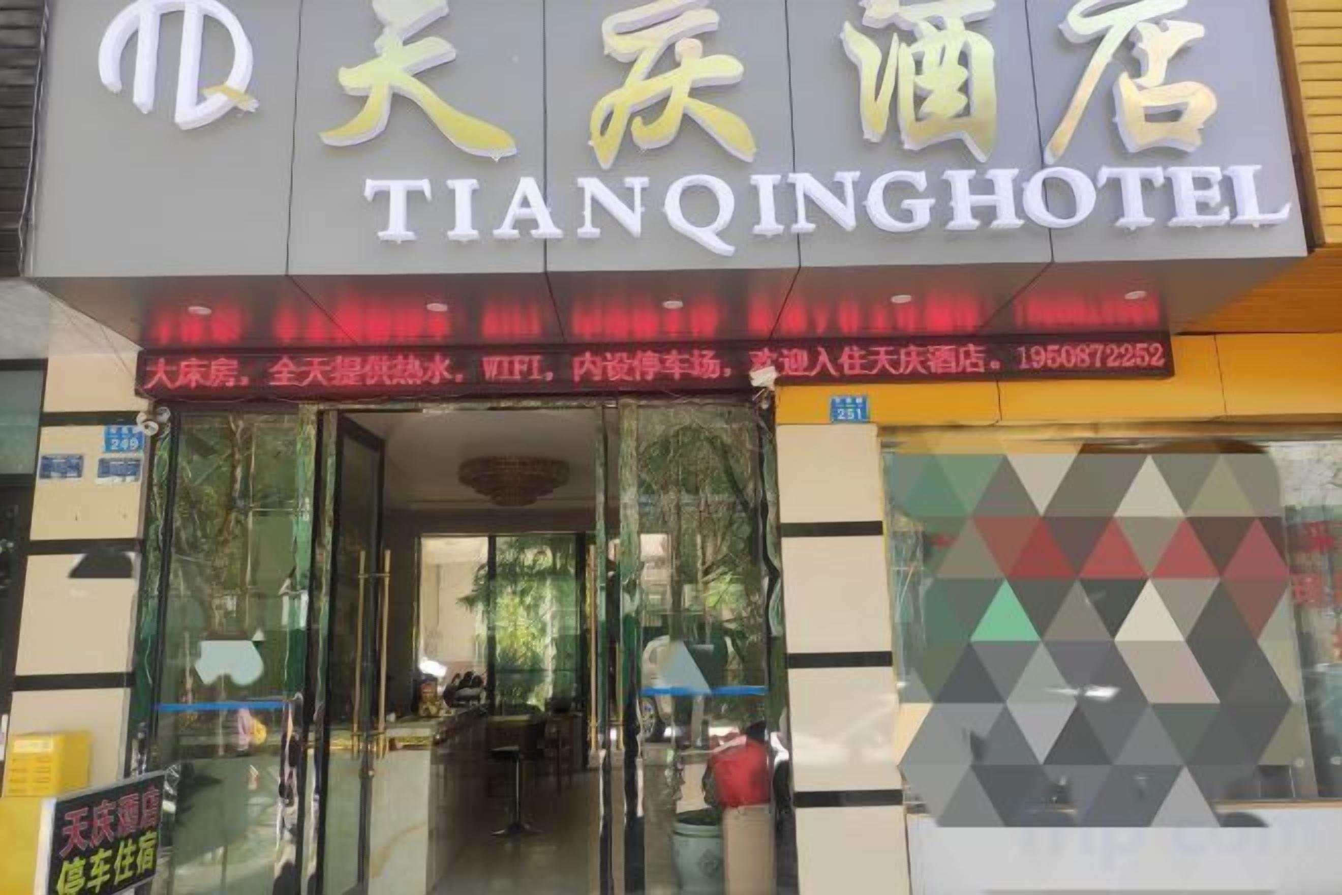 The exterior of Tianqing Hotel with a glass entrance, signage in both Chinese and English, and a visible restaurant area inside.