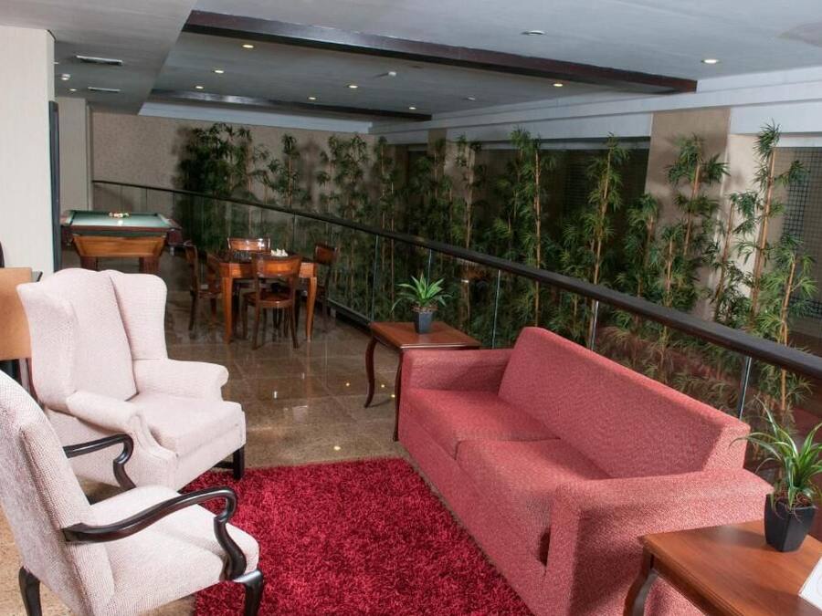 A hotel lobby with a pool table, a red sofa, and a red carpet.
