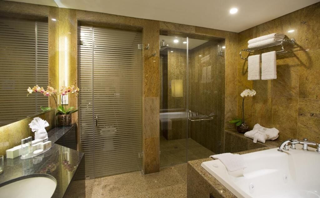 A modern bathroom with a glass-enclosed shower, a large bathtub, and a vanity with a mirror and sink.