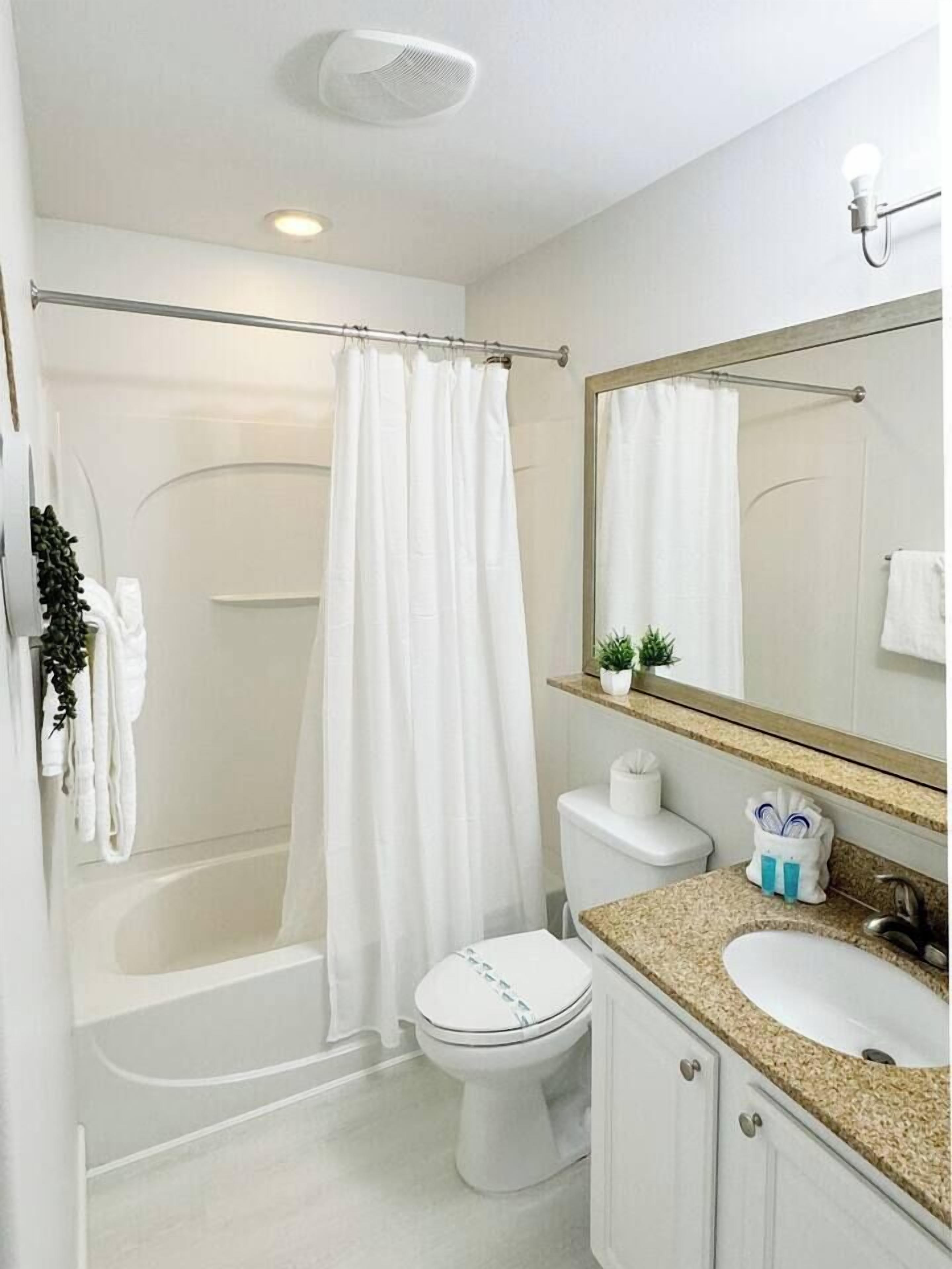 A modern bathroom with a bathtub, toilet, and sink.