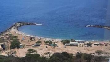 Une vue sur la côte, avec une plage, une piscine et un ciel dégagé.