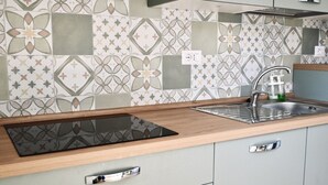 A kitchen with a patterned backsplash, a built-in stove, a sink, and a soap dispenser. - S343 - Sirolo, new three-room apartment with a/c and parking space (Sirolo)