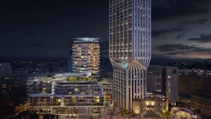Un hôtel moderne, doté d’un grand nombre d’étages, d’une architecture originale aux lignes courbes et d’une façade bien éclairée.