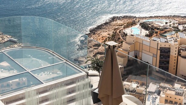 Un hôtel de grande hauteur, doté d’une façade en verre, qui offre une vue sur la côte.