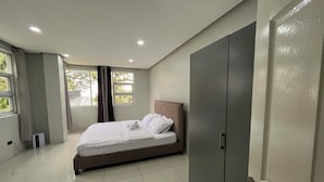 A bedroom with a bed, a wardrobe, a window, and a door. - A quiet and amazing place with mountain view and cool breeze of Baguio City. (Baguio City)