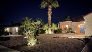 A residential property with a well-maintained garden, a tall palm tree, and a house with a blue door. - Stunningly designed, colorful, fun 3-bedroom house in Central Palm Springs. (Palm Springs)