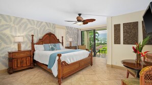 A spacious bedroom with a large bed, wooden headboard, and a ceiling fan. - Ocean View Studio at HBR, A/C Included (Princeville)