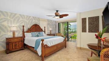 A spacious bedroom with a large bed, wooden headboard, and a ceiling fan.
