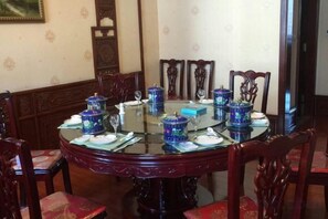 A round dining table with chairs, blue decorative items, and a glass top.