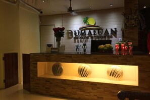 A reception desk with a sign that reads 'BUMALUAN HOTEL'.