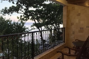 Uma varanda com vista para árvores e uma paisagem distante.