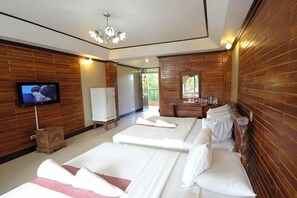 Une chambre d’hôtel avec deux lits, une télévision, une armoire et un miroir.