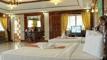 Een hotelkamer met twee bedden, een televisie, een bureau met stoel, en een spiegel.
