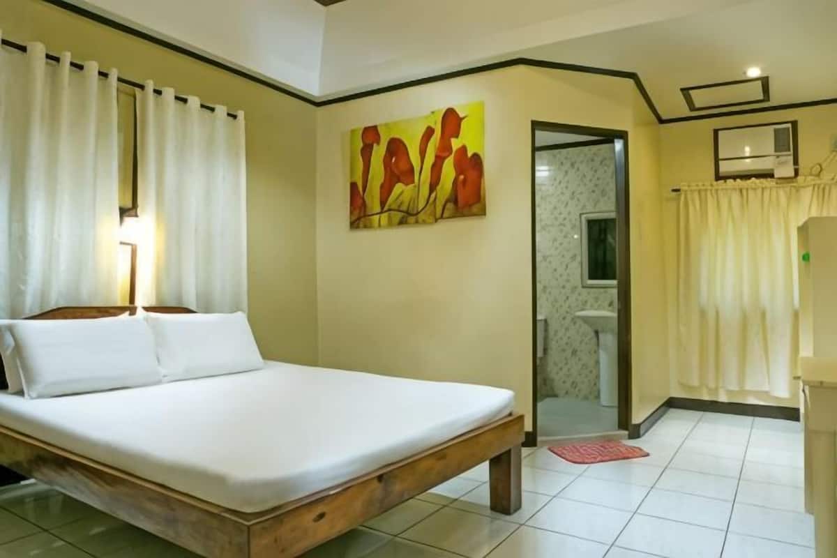 Une chambre à coucher comprenant un lit, un tableau, une salle de bain et un espace douche.