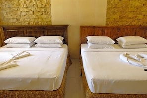 Two twin beds with wooden headboards, white bedding, and towels.