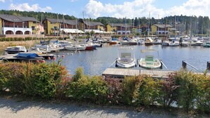 A marina with boats docked, surrounded by buildings with balconies and a clear sky.