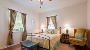 A bedroom with a bed, two bedside tables, a chair, and a ceiling fan. - Your Centrally Located C-Ville Home Away From Home Vacation Rental  (Charlottesville)