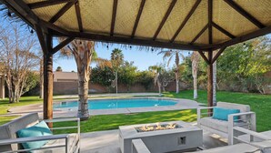 Patio esterno con piscina, zona salotto e area coperta.