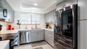 A modern kitchen with stainless steel appliances, grey cabinets, and a white countertop. - Palm Springs 2BR Mountain View Pool Home (Palm Springs)