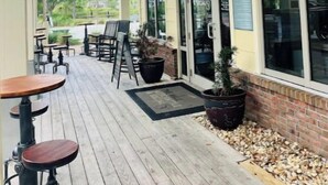 An outdoor seating area with tables and chairs, a sign reading "The Mill Mercantile & Social," and large windows. - Fall Break is Coming Up! Coastal Home- Walk,Bike, Golf Cart 2 Pools & Beach.  (Port St. Joe)