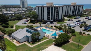 A hotel with a swimming pool, parking lot, and a view of the ocean. - OCEAN PEARL 2-bedroom condo in peaceful Destin  (Destin)